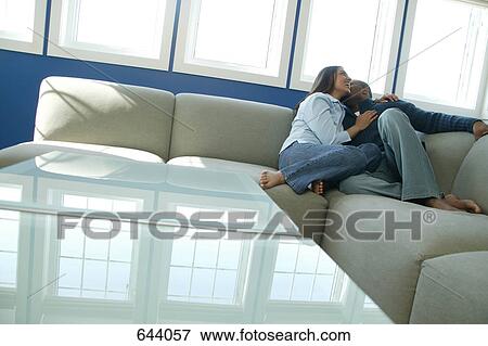 Stock Photo - Couple snuggles on sofa. Fotosearch