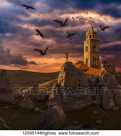 Crows flying towards a church tower with a wooden human mannequin laying on the ground in the foreground View Large Photo Image Stock Photograph - Crows flying towards a church tower with a wooden human mannequin laying on the ground in the foreground. Fotosearch
