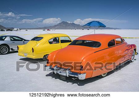 Customized spectator cars at Bonneville Speed Week on Bonneville Salt Flats. Yellow Henry J and Mercury Coupe with flames, both from early 1950s; Wendover, Utah, United States of America View Large Photo Image Stock Photograph - Customized spectator cars at Bonneville Speed Week on Bonneville Salt Flats. Yellow Henry J and Mercury Coupe with flames, both from early 1950s; Wendover, Utah, United States of America. Fotosearch