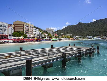 Stock Photograph - Dock at the waterfront with resorts and people along the beach; Philipsburg, St Maarten. Fotosearch
