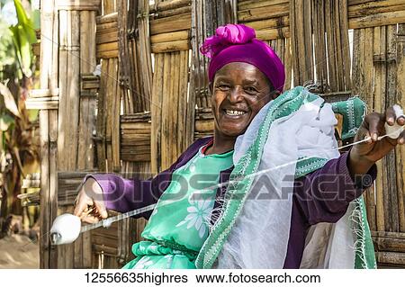 Stock Photograph - Dorze woman spinning cotton, Dorze village; Southern Nations Nationalities and Peoples' Region, Ethiopia. Fotosearch