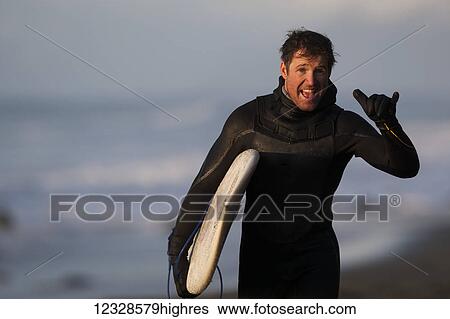Enthusiastic surfer holding a surfboard along coast Southeast Alaska; Yakutat, Alaska, United States of America View Large Photo Image Stock Photograph - Enthusiastic surfer holding a surfboard along coast Southeast Alaska; Yakutat, Alaska, United States of America. Fotosearch