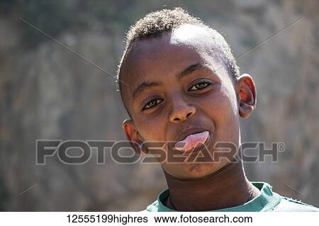 Eritrean boy sticking out his tongue for the camera; Arbaroba, Central Province, Eritrea View Large Photo Image Stock Photograph - Eritrean boy sticking out his tongue for the camera; Arbaroba, Central Province, Eritrea. Fotosearch