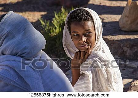 Stock Photograph - Ethiopian boy attending a prayer service outside of Abreha we Atsbeha church; Tigray Region, Ethiopia. Fotosearch