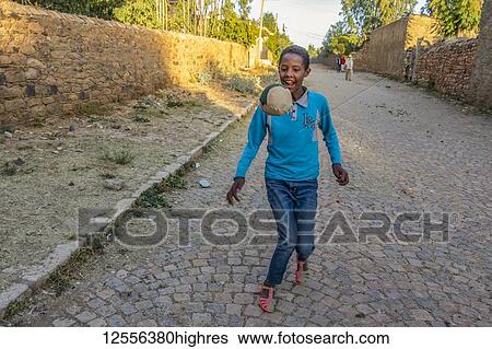 Stock Photograph - Ethiopian boy playing football; Axum, Tigray Region, Ethiopia. Fotosearch