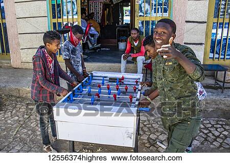 Stock Photograph - Ethiopian boys playing table football on a street outside a barbershop; Agula, Tigray Region, Ethiopia. Fotosearch