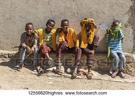 Stock Photograph - Ethiopian boys sitting and laughing, Harar Jugol, the Fortified Historic Town; Harar, Harari Region, Ethiopia. Fotosearch