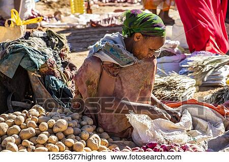 Stock Photograph - Ethiopian woman selling potatoes at the weekly market; Abreha we Atsbeha, Tigray, Ethiopia. Fotosearch