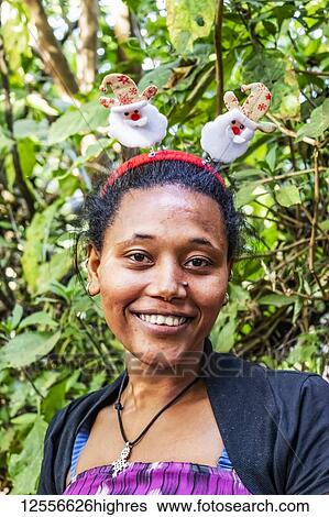 Stock Photograph - Ethiopian woman wearing a Christmas headband, Lake Tana; Amhara Region, Ethiopia. Fotosearch