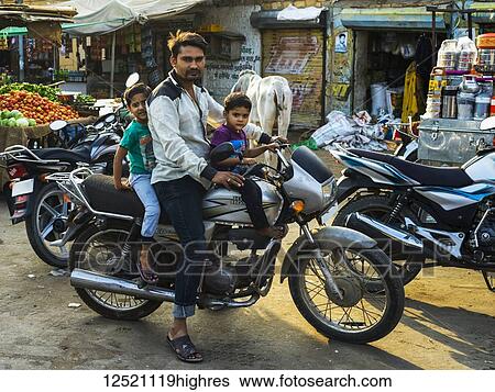 Father with two young sons on a motorcycle; Jaisalmer, Rajasthan, India View Large Photo Image Stock Photograph - Father with two young sons on a motorcycle; Jaisalmer, Rajasthan, India. Fotosearch