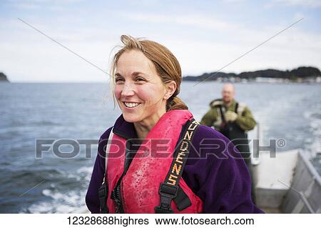 Stock Photograph - Female and husband drives a set-net skiff in Seldovia Bay, South-central Alaska; Alaska, United States of America. Fotosearch