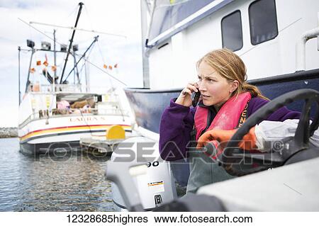 Female set-netter talking on a cell phone, Seldovia Harbor, Kachemak Bay, South-central Alaska; Alaska, United States of America View Large Photo Image Stock Photograph - Female set-netter talking on a cell phone, Seldovia Harbor, Kachemak Bay, South-central Alaska; Alaska, United States of America. Fotosearch