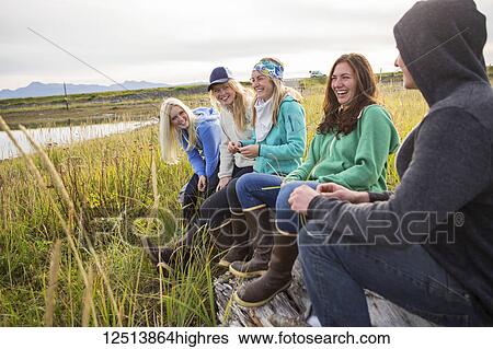 Five friends hang out on a driftwood log along coastal Homer, South-central Alaska; Homer, Alaska, United States of America View Large Photo Image Stock Photograph - Five friends hang out on a driftwood log along coastal Homer, South-central Alaska; Homer, Alaska, United States of America. Fotosearch