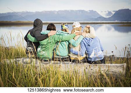 Five friends hang out on a driftwood log along coastal Homer, South-central Alaska; Homer, Alaska, United States of America View Large Photo Image Stock Photograph - Five friends hang out on a driftwood log along coastal Homer, South-central Alaska; Homer, Alaska, United States of America. Fotosearch