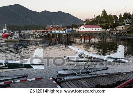 Stock Photograph - Float planes docked in Clayoquot Sound at sunset on the Pacific Rim, Vancouver Island; Tofino, British Columbia, Canada. Fotosearch