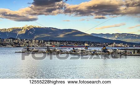 Stock Photograph - Float planes in a harbour at dusk; Vancouver, British Columbia, Canada. Fotosearch