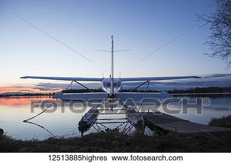 Stock Photograph - Floatplane moored at Lake Hood at sunset with Mt. Susitna in the background, South-central Alaska; Anchorage, Alaska, United States of America. Fotosearch