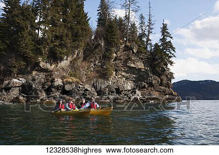 Stock Photograph - Four sea kayakers in tandem kayaks, Kachemak Bay, South-central Alaska; Alaska, United States of America. Fotosearch