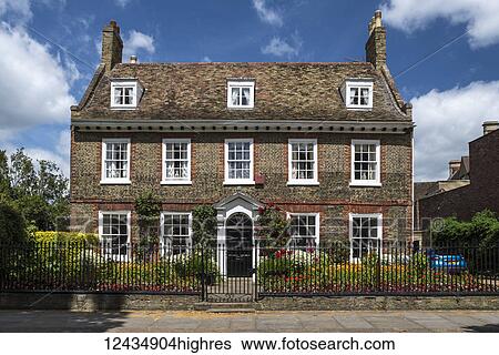 Georgian town house with a wrought iron fence and colourful flower garden in the front yard View Large Photo Image Stock Photograph - Georgian town house with a wrought iron fence and colourful flower garden in the front yard. Fotosearch