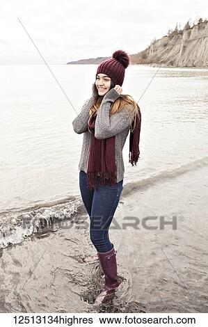 Girl standing in shallow water in autumn at the Scarborough Bluffs wearing a knit hat and scarf; Toronto, Ontario, Canada View Large Photo Image Stock Photograph - Girl standing in shallow water in autumn at the Scarborough Bluffs wearing a knit hat and scarf; Toronto, Ontario, Canada. Fotosearch
