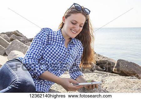 Girl using tablet at Woodbine beach in summer; Toronto, Ontario, Canada View Large Photo Image Stock Photograph - Girl using tablet at Woodbine beach in summer; Toronto, Ontario, Canada. Fotosearch