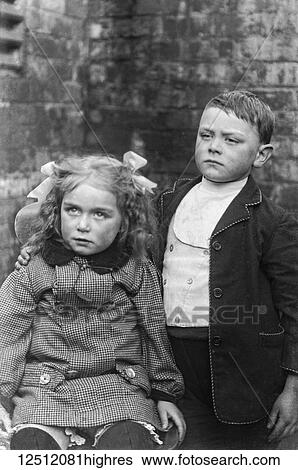 Stock Photograph - Glass Negative circa 1900. Victorian. Social History. Children, probably a family pose in the backyard for a photograph. A boy and a girl. Fotosearch