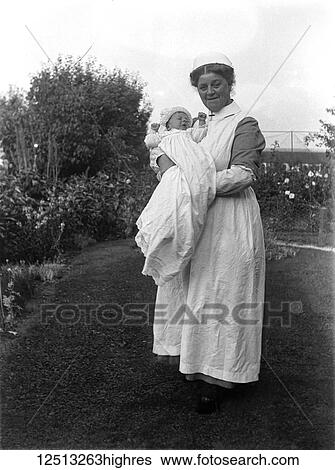 Stock Photograph - Glass Negative circa 1900. Victorian. Social History. nanny with baby in garden. Fotosearch