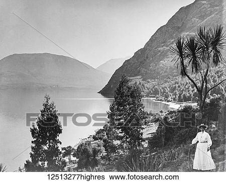 Stock Photograph - Glass Negative circa 1900. Victorian. Social History. A victorian lady in best dress at said of lake in New Zealand. Fotosearch