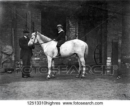 Glass Negative circa 1900. Victorian. Social History. Young boy on white horse in stable yard with adult supervising View Large Photo Image Stock Photograph - Glass Negative circa 1900. Victorian. Social History. Young boy on white horse in stable yard with adult supervising. Fotosearch