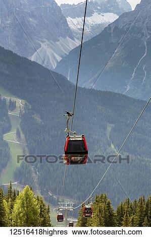 Gondola cabins along cable with steep alpine slopes and mountains in the distance; Sesto, Bolzano, Italy View Large Photo Image Stock Photograph - Gondola cabins along cable with steep alpine slopes and mountains in the distance; Sesto, Bolzano, Italy. Fotosearch