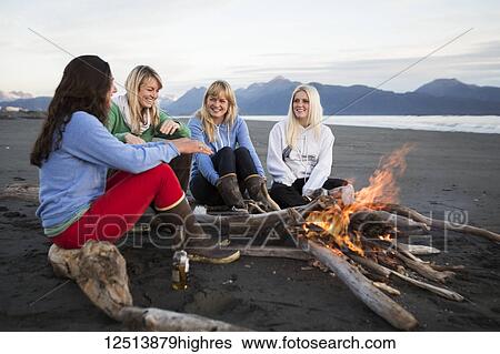 Stock Photograph - Group of friends hanging out on the Homer beach, Kachemak Bay, South-central Alaska; Homer, Alaska, United States of America. Fotosearch