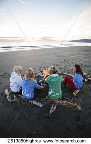 Stock Photograph - Group of friends hanging out on the Homer beach, Kachemak Bay, South-central Alaska; Homer, Alaska, United States of America. Fotosearch