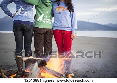 Stock Photograph - Group of friends hanging out on the Homer beach, Kachemak Bay, South-central Alaska; Homer, Alaska, United States of America. Fotosearch