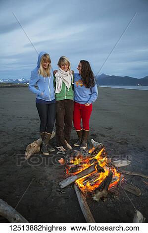 Stock Photograph - Group of friends hanging out on the Homer beach, Kachemak Bay, South-central Alaska; Homer, Alaska, United States of America. Fotosearch