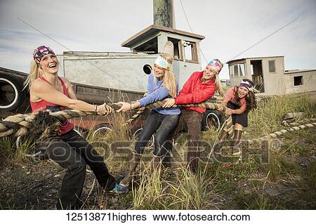 Group of friends playing tug with a large rope along coastal Homer, South-central Alaska; Homer, Alaska, United States of America View Large Photo Image Stock Photograph - Group of friends playing tug with a large rope along coastal Homer, South-central Alaska; Homer, Alaska, United States of America. Fotosearch