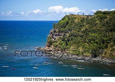 Stock Photograph - Group of paddler boarders and stand up paddle boarders, paddling from Maliko for a coast run on the North shore of Maui; Paia, Maui, Hawaii, United States of America. Fotosearch