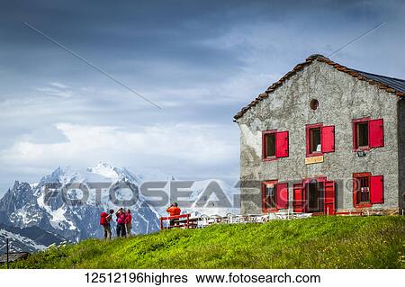 Stock Photograph - Hikers looking at Mount Blanc from Refuge du Col de Balme at the Swiss-French border, Alps; France. Fotosearch