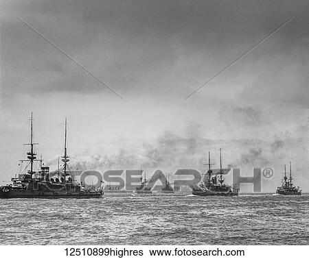 Stock Photograph - Historic black and white image of ships on the ocean under a cloudy sky. Fotosearch