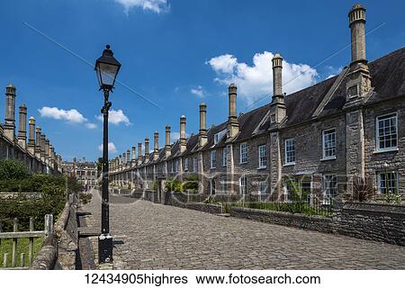 Stock Photograph - Historic houses on Vicars' Close with a street lamp and cobblestone street. Built between 1348 and 1430, Vicars Close is claimed to be the oldest purely residential street with its original buildings all surviving intact in Europe; Wells, Somerset,.... Fotosearch