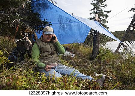 Hunter Talks On A Satellite Phone During A Remote Moose Hunt, Lake Iliamna, Southwest Alaska, USA View Large Photo Image Stock Photograph - Hunter Talks On A Satellite Phone During A Remote Moose Hunt, Lake Iliamna, Southwest Alaska, USA. Fotosearch