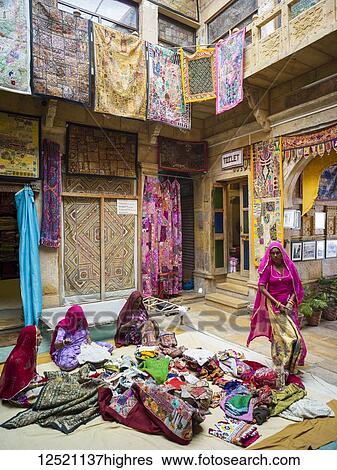 Indian women sitting on the ground and sewing with colourful textiles; India View Large Photo Image Stock Photograph - Indian women sitting on the ground and sewing with colourful textiles; India. Fotosearch