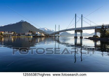 Stock Photograph - John O'Connell bridge reflected in the Sitka harbour and the town of Sitka in winter with Mount Versovia in the background; Sitka, Alaska, United States of America. Fotosearch