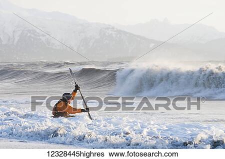 Stock Photograph - Kayak surfer paddling through rough waters, Kachemak Bay, South-central Alaska; Homer, Alaska, United States of America. Fotosearch