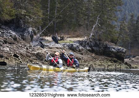 Stock Photograph - Kayakers in Kachemak Bay in spring, South-central Alaska; Alaska, United States of America. Fotosearch