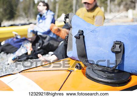Stock Photograph - Kayakers relax on shore, Kachemak Bay, South-central Alaska; Alaska, United States of America. Fotosearch
