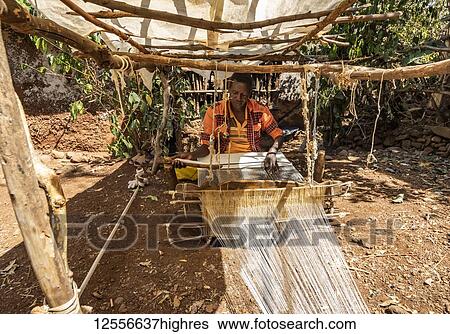 Stock Photograph - Konso man weaving cloth on his loom; Karat-Konso, Southern Nations Nationalities and Peoples' Region, Ethiopia. Fotosearch