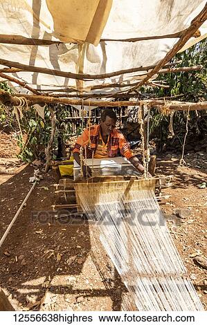Stock Photograph - Konso man weaving cloth on his loom; Karat-Konso, Southern Nations Nationalities and Peoples' Region, Ethiopia. Fotosearch
