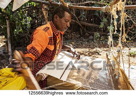 Stock Photograph - Konso man weaving cloth on his loom; Karat-Konso, Southern Nations Nationalities and Peoples' Region, Ethiopia. Fotosearch