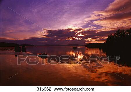 Lake at sunset on cloudy day with speed boat View Large Photo Image Stock Image - Lake at sunset on cloudy day with speed boat. Fotosearch