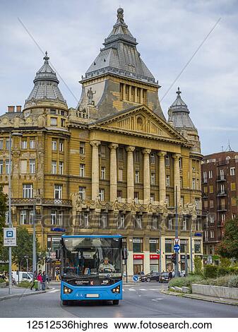 Large building with ornate facade of columns and statues and a bus on the street; Budapest, Budapest, Hungary View Large Photo Image Stock Photograph - Large building with ornate facade of columns and statues and a bus on the street; Budapest, Budapest, Hungary. Fotosearch